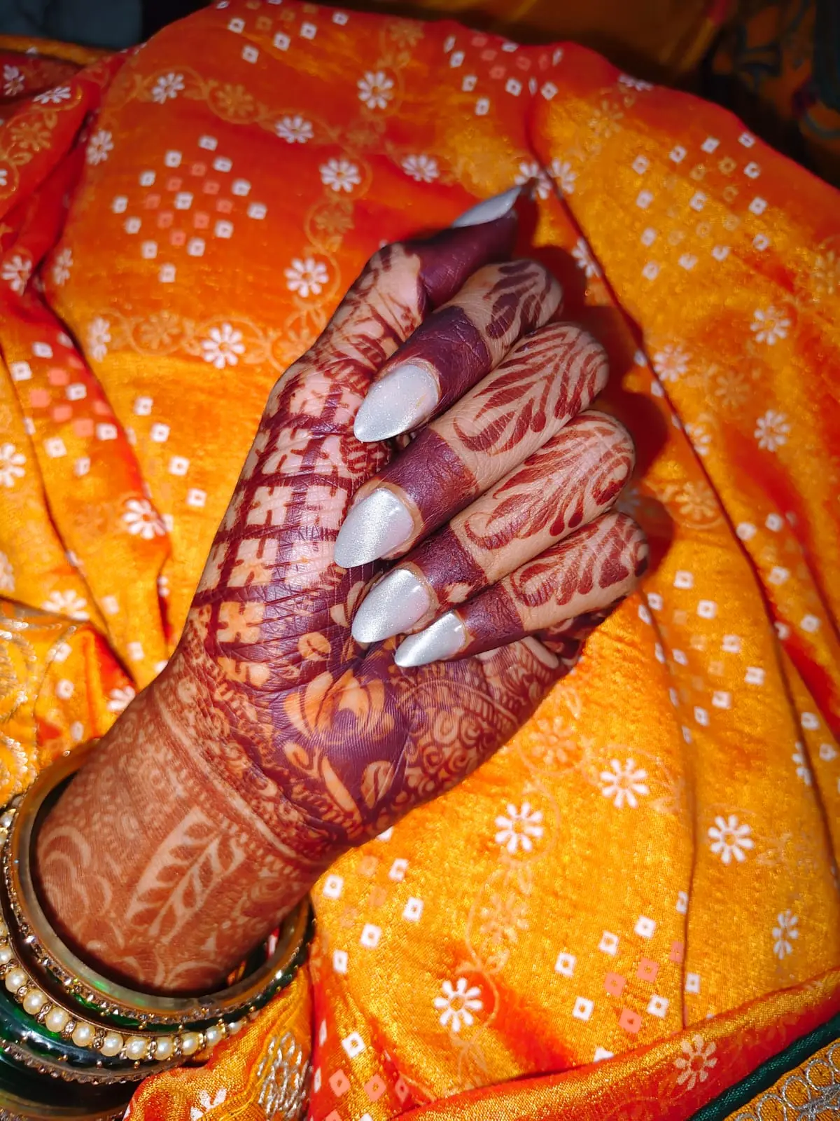 Bridal hands with mehendi and pearl-finish nails